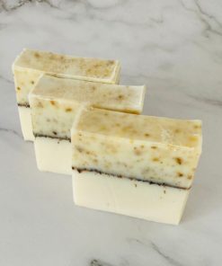 pure & pretty Dhana Soap bar RTSB01 has yellow variation on the top a black line across the middle and white on the bottom. Three bars of soap sit in a row. The soap is unscented with ground chamomile flowers.