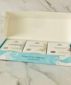 three soap bars in white boxes in a long narrow turquoise box