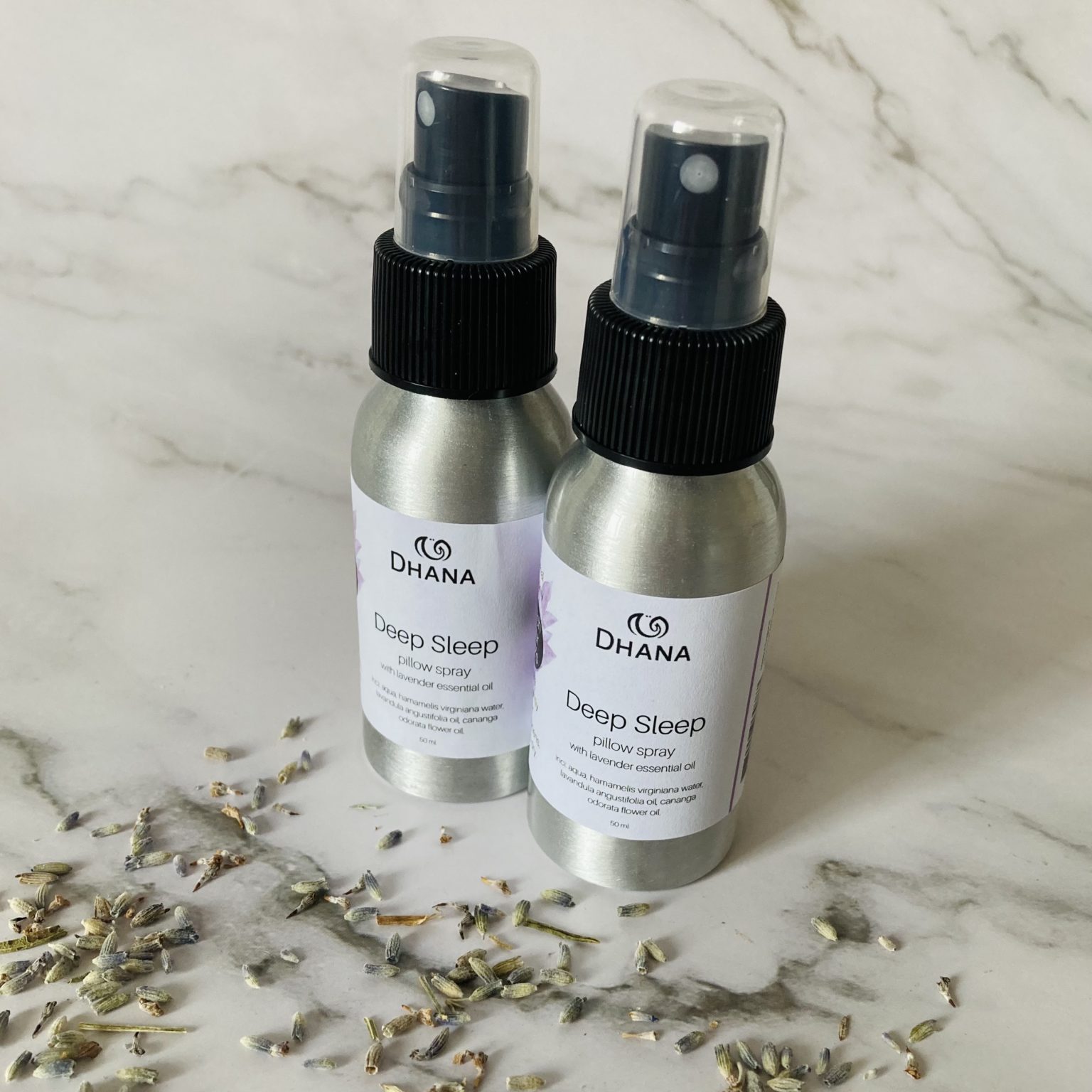 aluminum bottles of deep sleep pillow spray with lavender and marble background