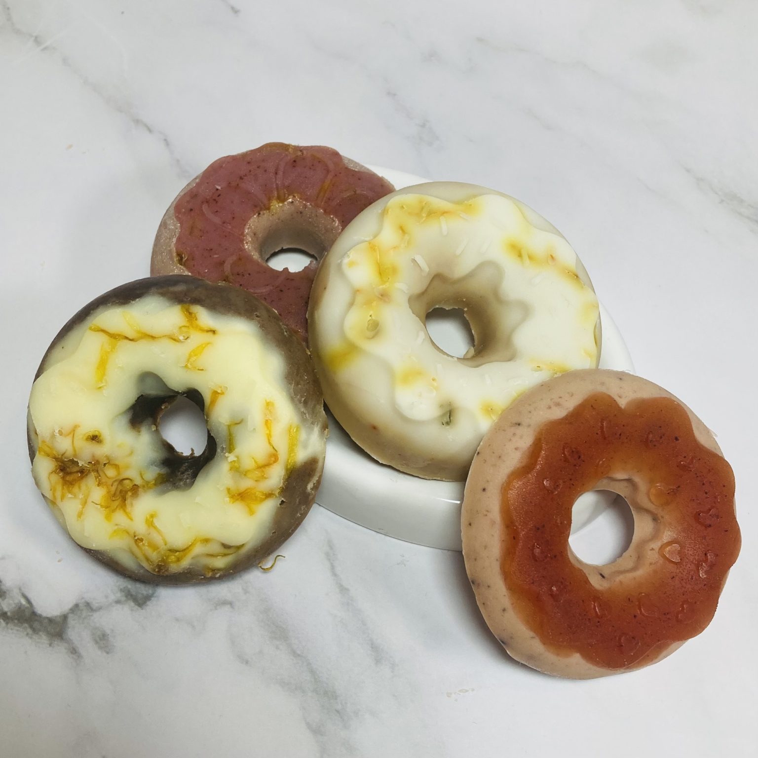 four donut soaps in various colours cocoa, calendula, madder root and vanilla look for Chanukah theme gift soaps