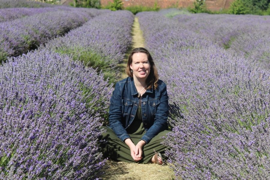 Ashley, founder of Dhana Self-Care, in a lavender field