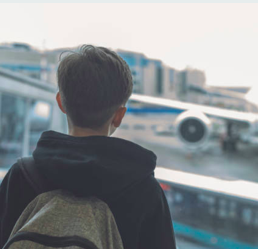 feedback photo: boy looking out airport window at airplane