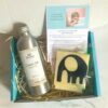 Children's Castor Oil Pack Kit (contains aluminium bottle of oil, instructions, elephant oil protector on top of cotton flannel, with instructions all in turquoise box on marble background.)
