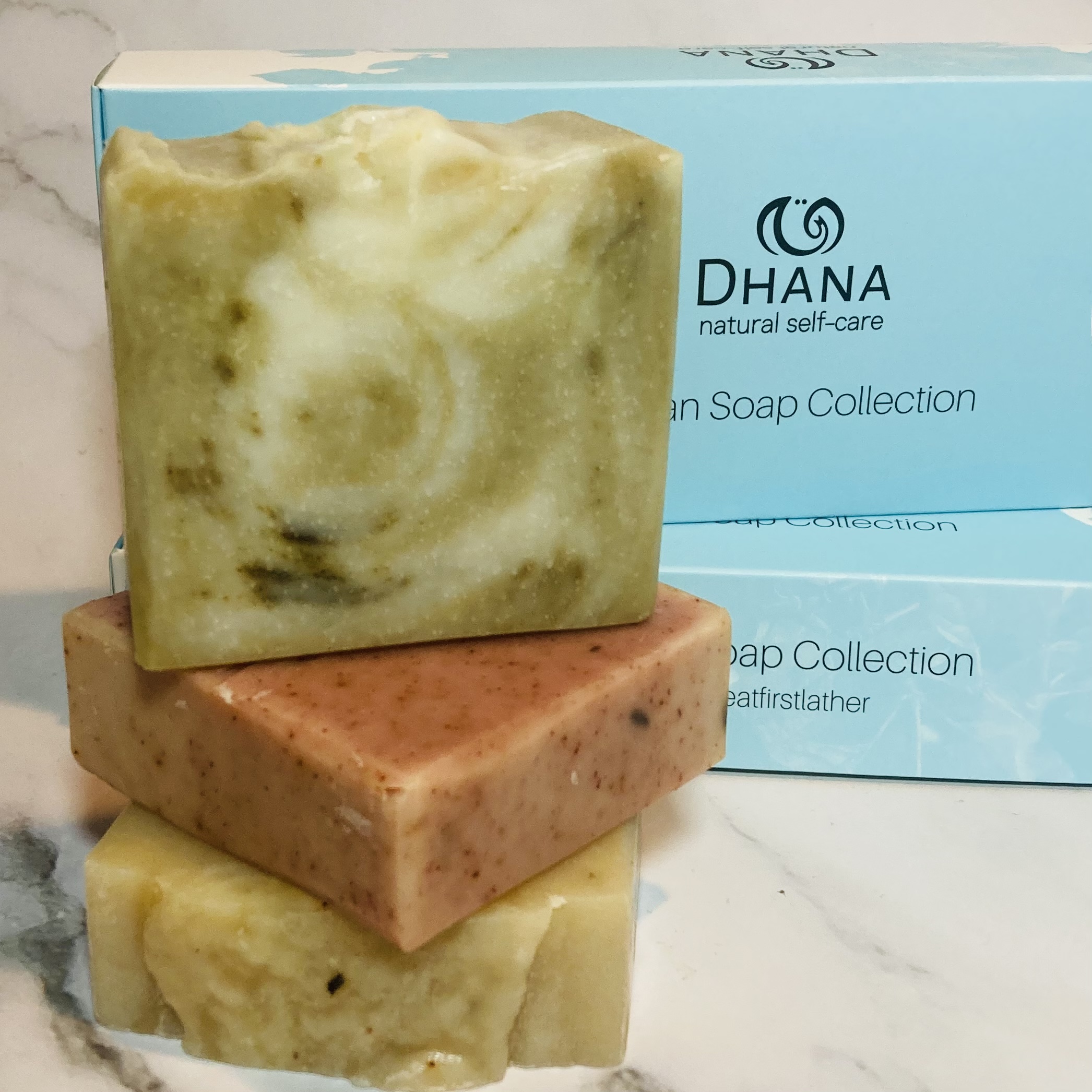 head to toe soap collection - stack of 3 soaps: green swirly, pink and brown with turquoise box behind.