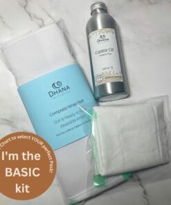 Dhana Self-Care Basic Castor Oil Pack Kit (contains flannel folded, bottle of oil, and Compress wrap belt) on white marble background.