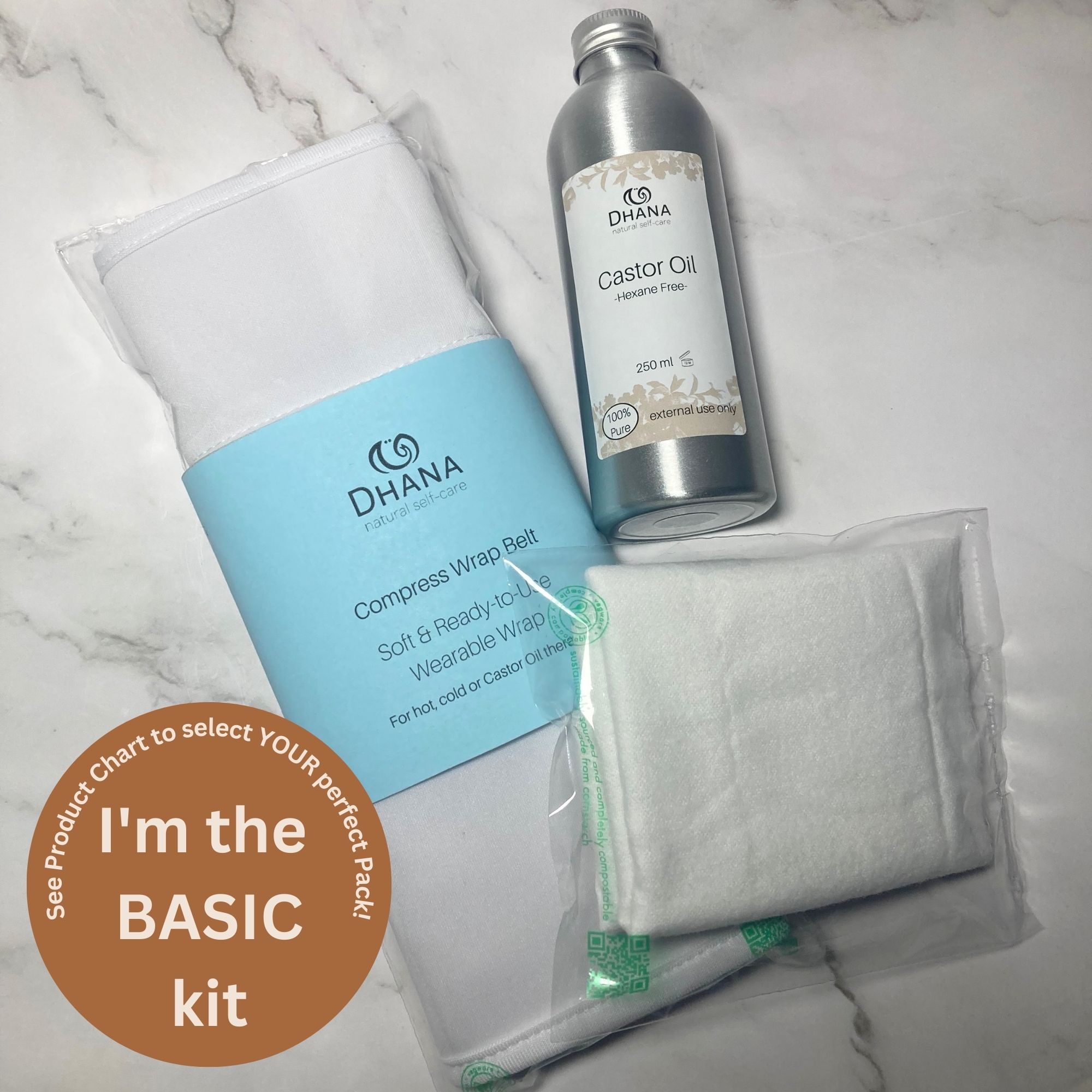 Dhana Self-Care Basic Castor Oil Pack Kit (contains flannel folded, bottle of oil, and Compress wrap belt) on white marble background.