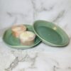 green soap dishes on a marble background