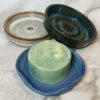 three small soap dishes in brown blue and dark green
